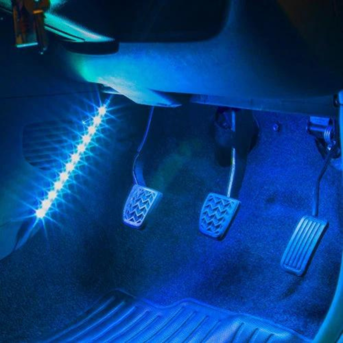 Blauwe LED-strips verlichten autobesturingpedalen en vloermatten.