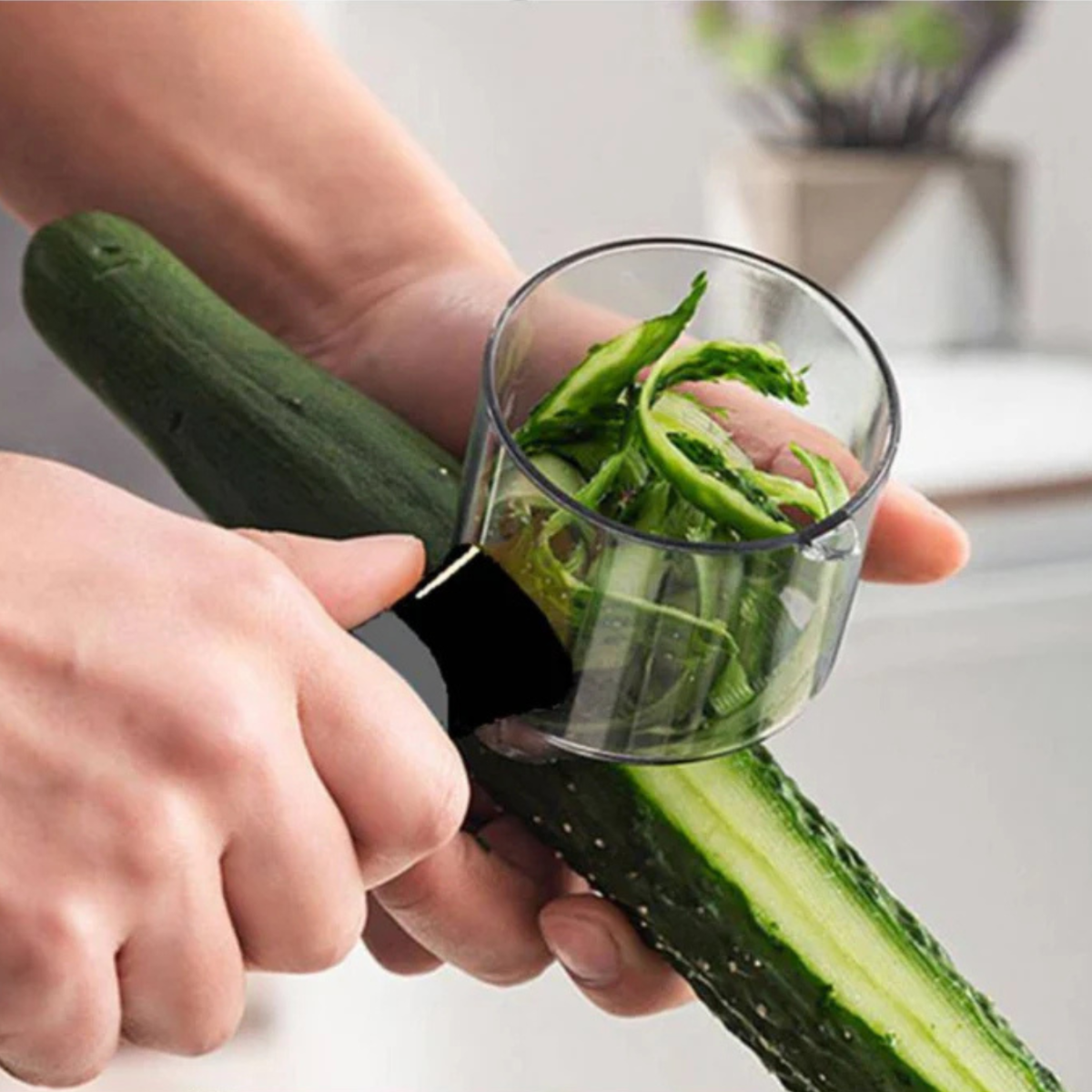 A cucumber is being spiralized into ribbons by a kitchen gadget.