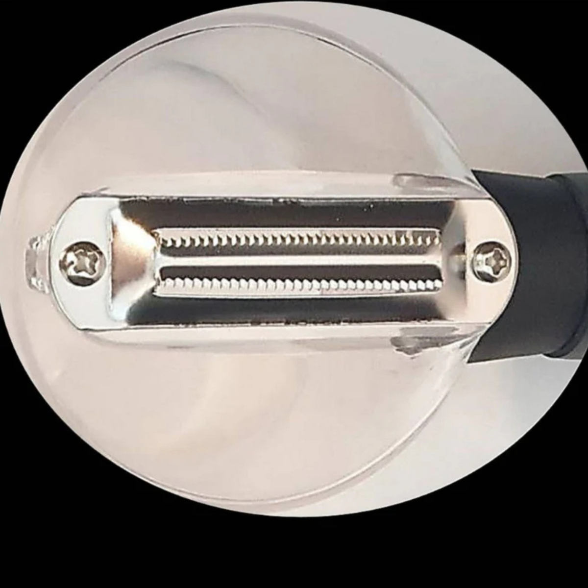 Close-up of a peeler with two rows of teeth and screws.