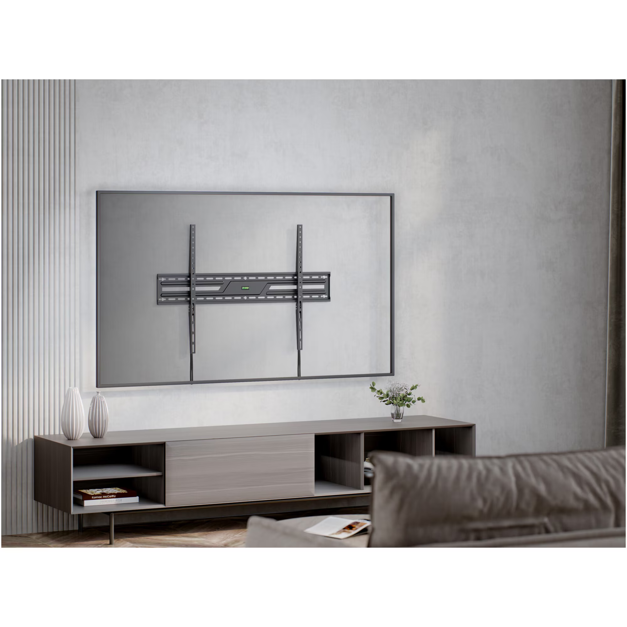 Ein großer Fernseher mit Wandhalterung steht über einem grauen Sideboard mit Vasen und Büchern.