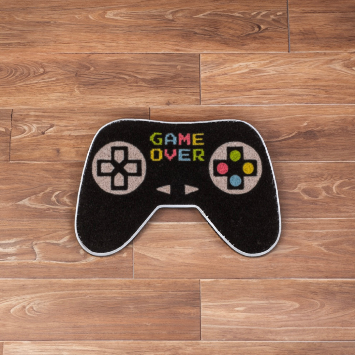 Een zwarte gamecontroller-mat met "GAME OVER" en gekleurde knoppen op een houten vloer.