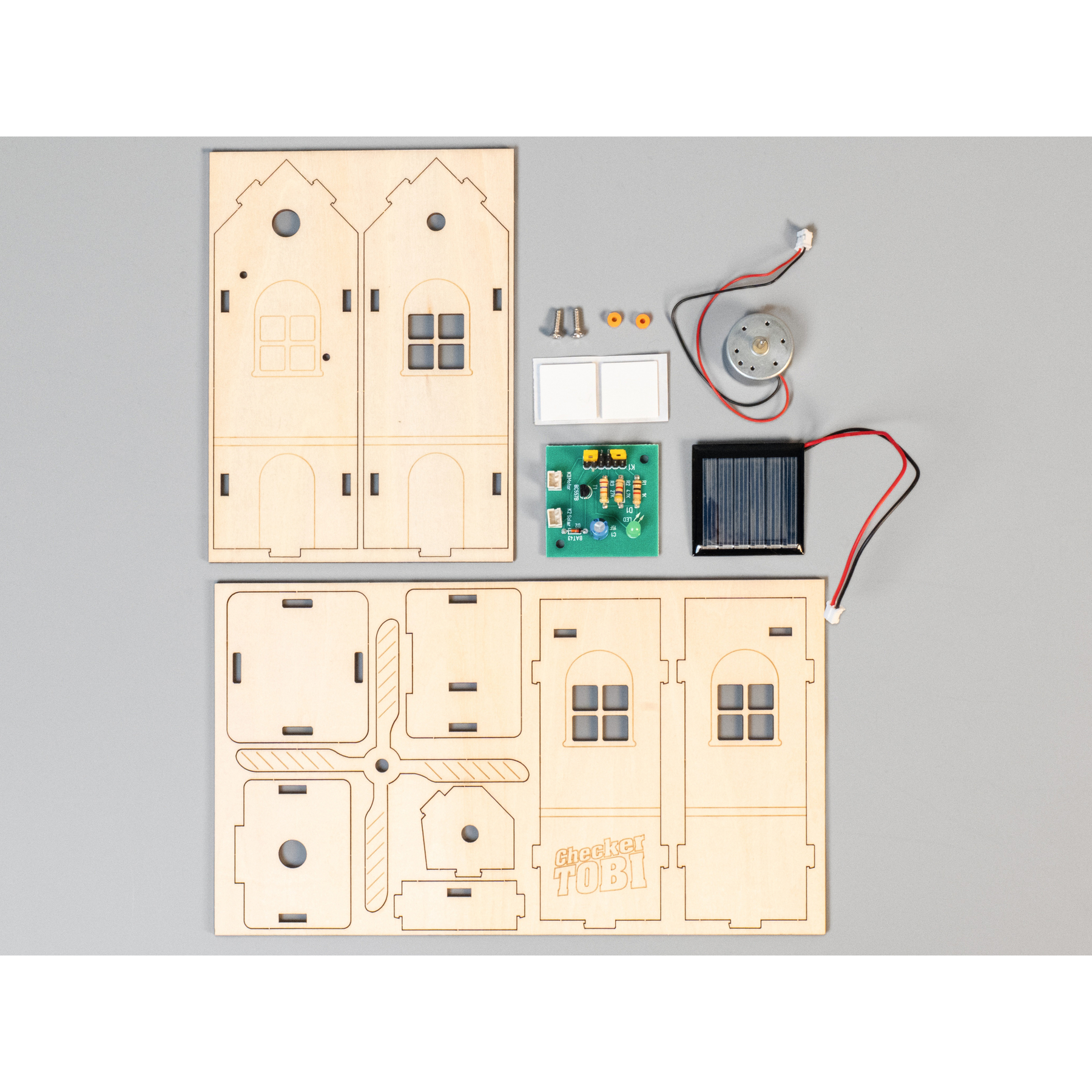 Holzbausatz für ein Haus mit Solarpanel, Motor und Platine.