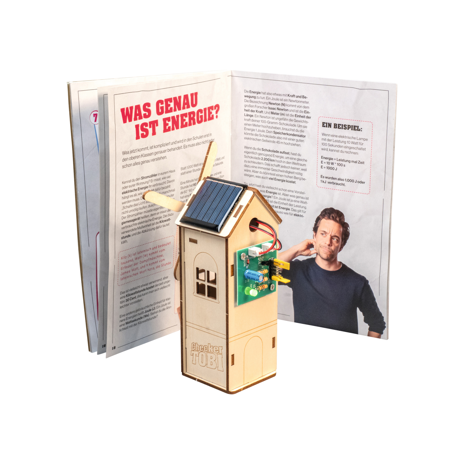 Ein Holzmodell eines Hauses mit Solarmodul und Elektronik, neben einem Buch.