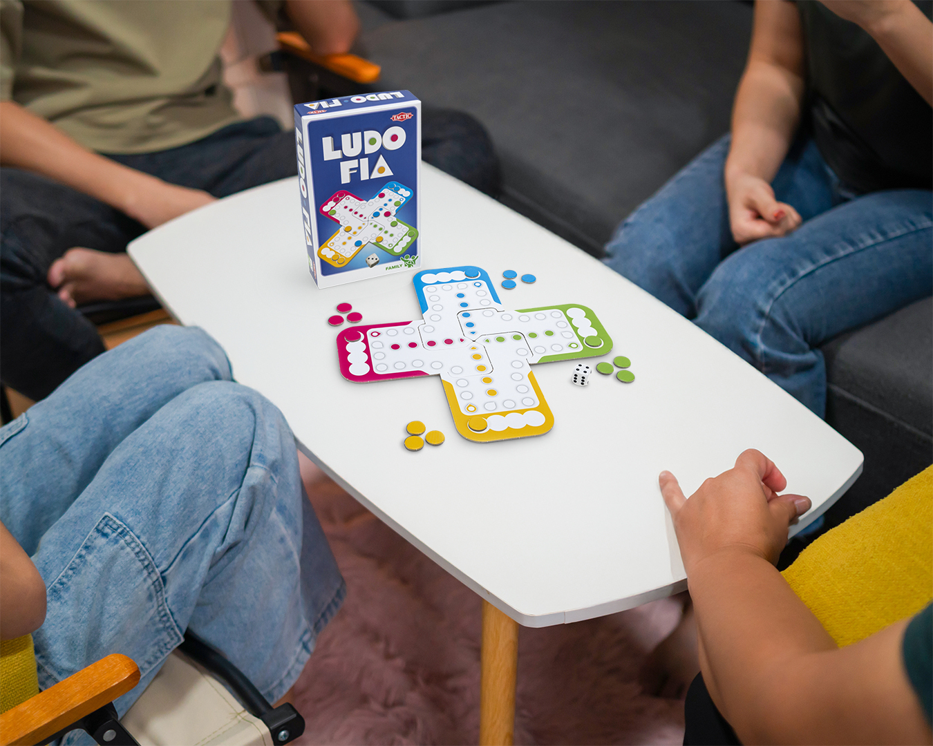 Ludo Fia speelbord met pionnen, dobbelstenen en een speldoos op een witte tafel.