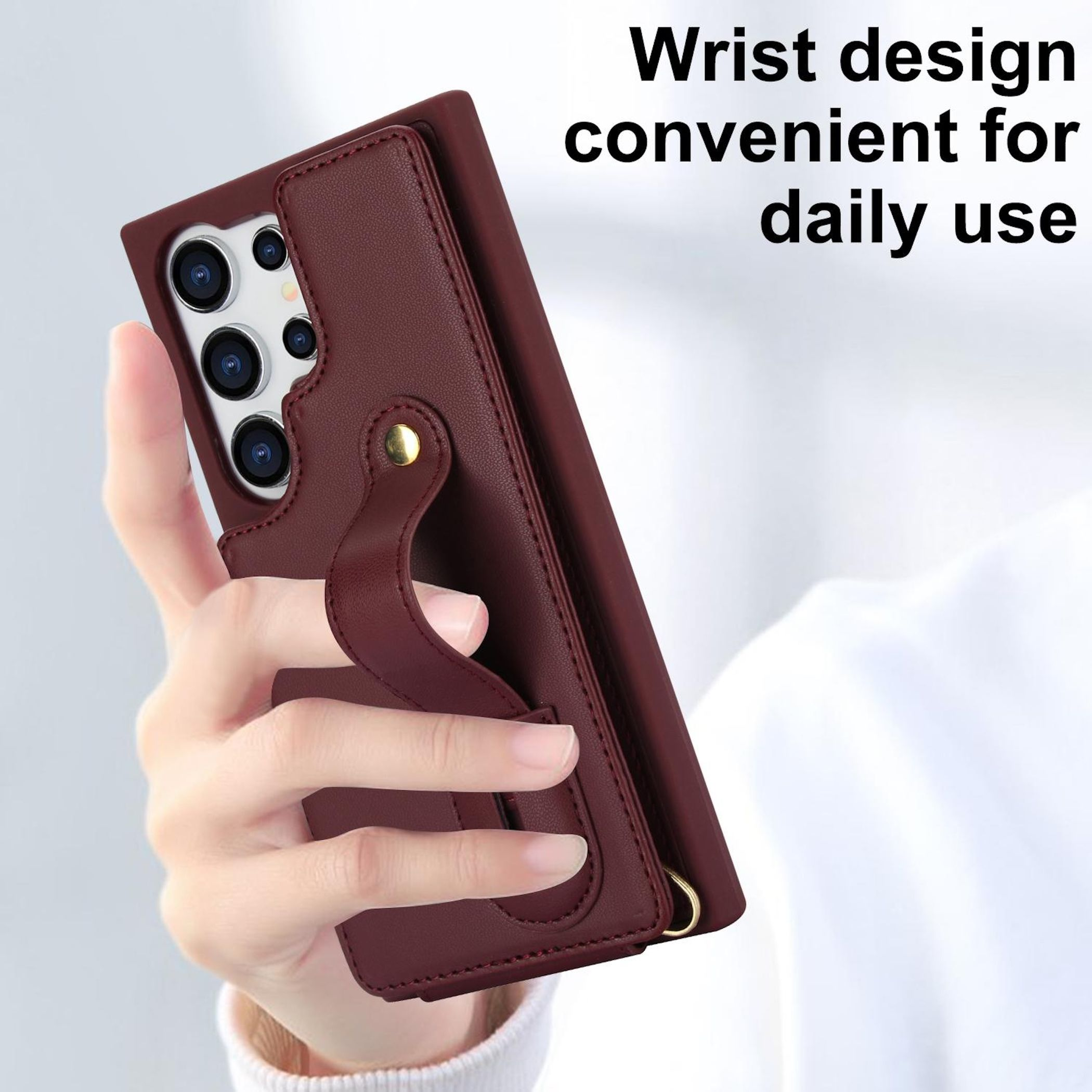 Eine Hand hält ein dunkelrotes Handycover mit integrierter Handschlaufe.