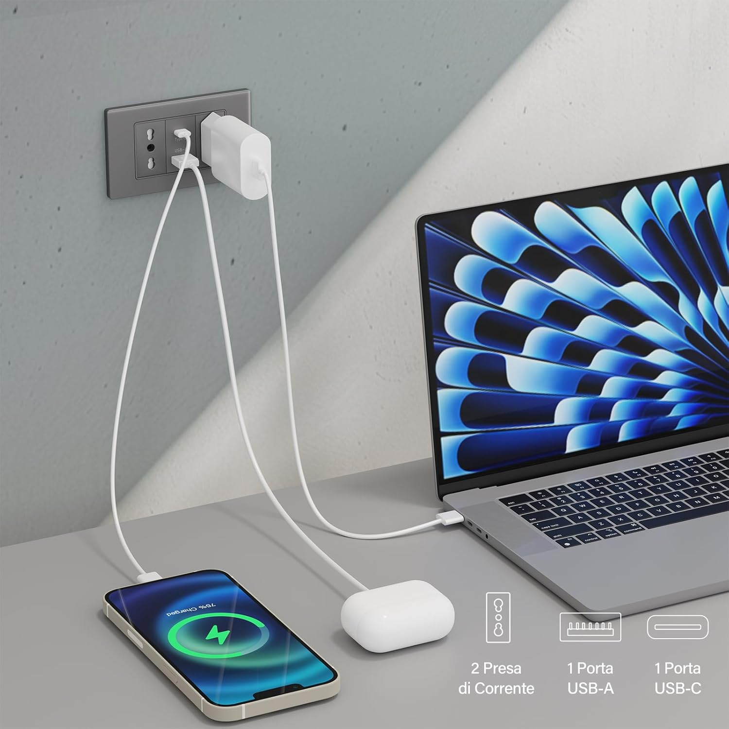 Un adattatore di ricarica bianco è collegato a una presa a muro. Un laptop e un telefono sono in carica.