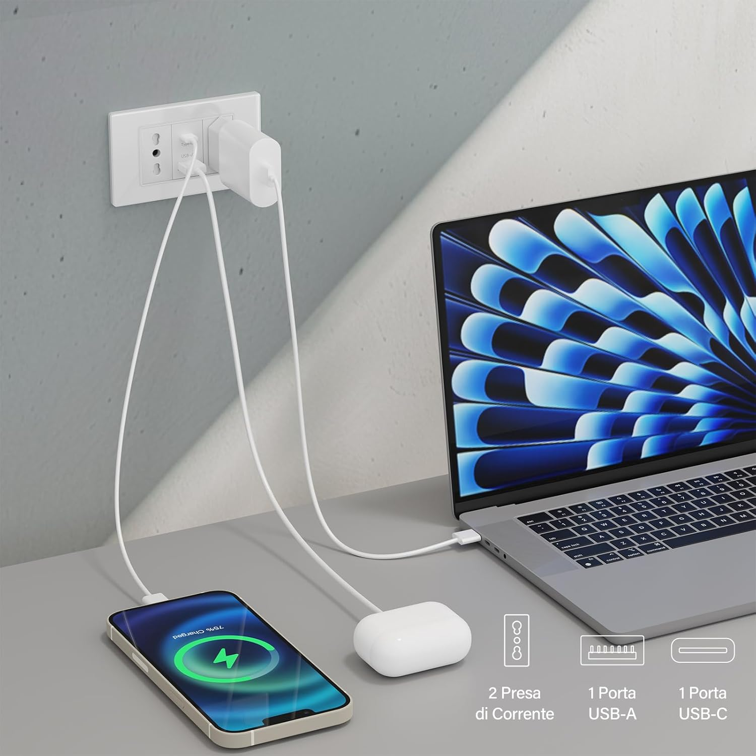 Un laptop, un telefono e auricolari bianchi sono collegati a una presa di corrente.