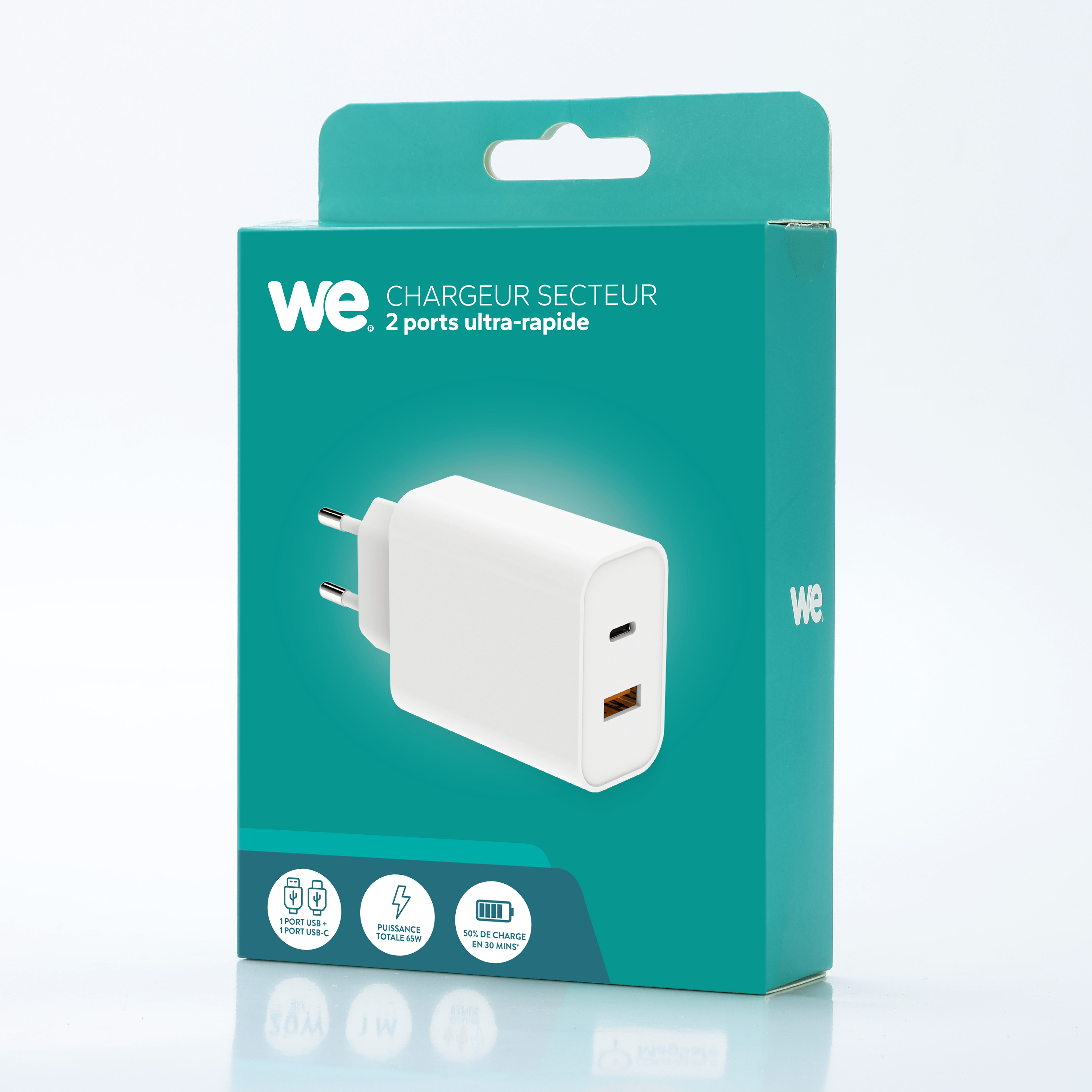 Cargador blanco con dos puertos USB-C y enchufe europeo en caja turquesa.