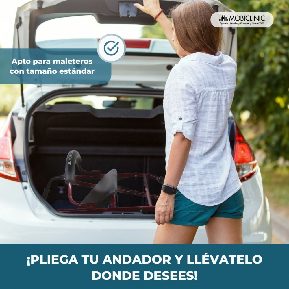 Mujer cargando un andador rojo en el maletero de un coche.