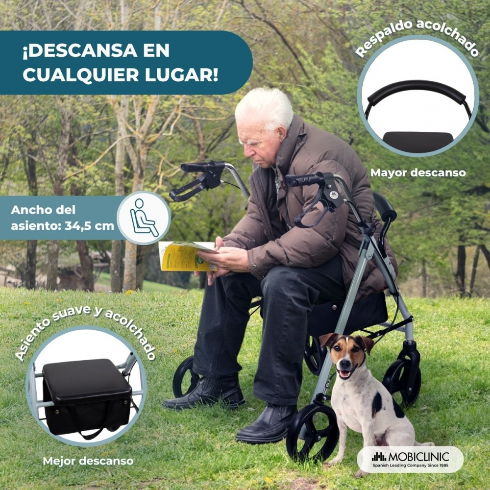 Hombre mayor lee libro junto a andador y perro al aire libre.