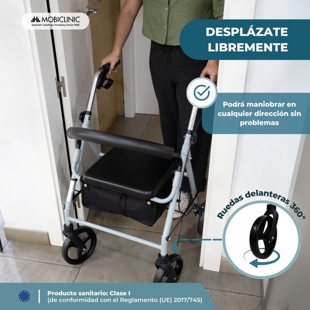 Una persona usa un andador gris con asiento y cesta. Ruedas delanteras 360°.