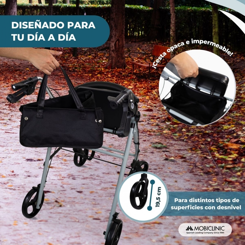 Un andador con bolsa negra en un camino exterior cubierto de hojas.