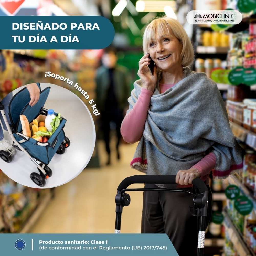 Una mujer con andador habla por teléfono en una tienda. Un carrito de compras está lleno.