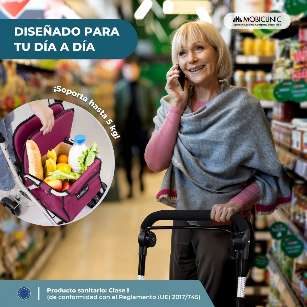 Una mujer mayor habla por teléfono mientras empuja un carrito de compras.
