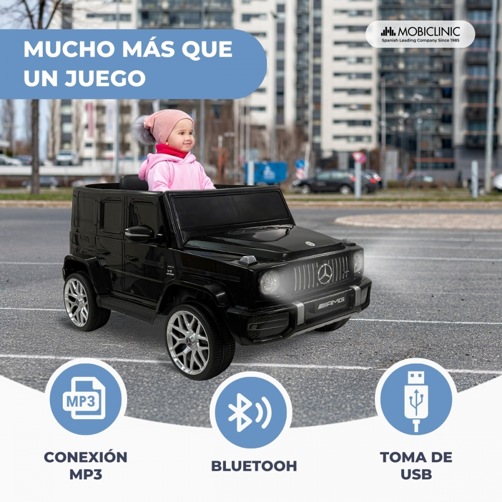 Un coche de juguete negro con un bebé dentro, al aire libre.
