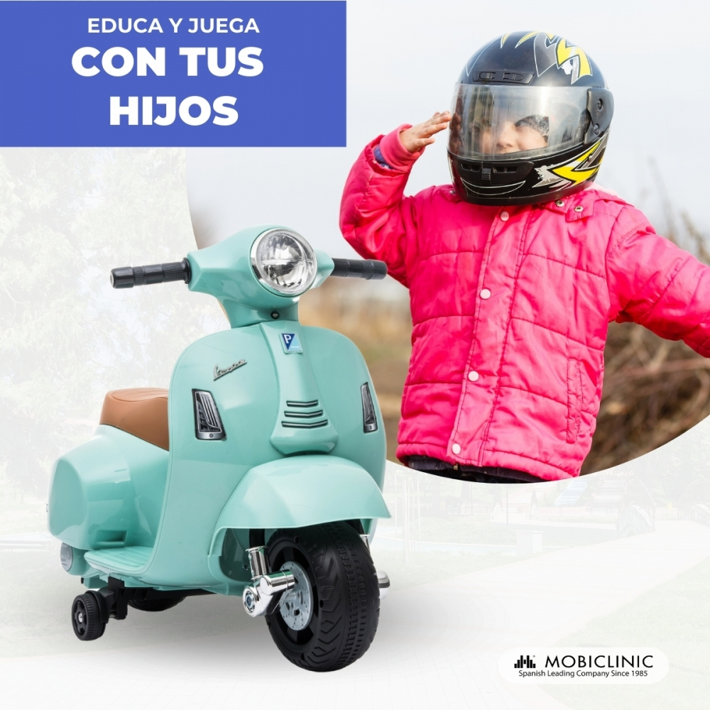 Un niño con chaqueta rosa y casco saluda junto a un patinete de juguete verde menta.