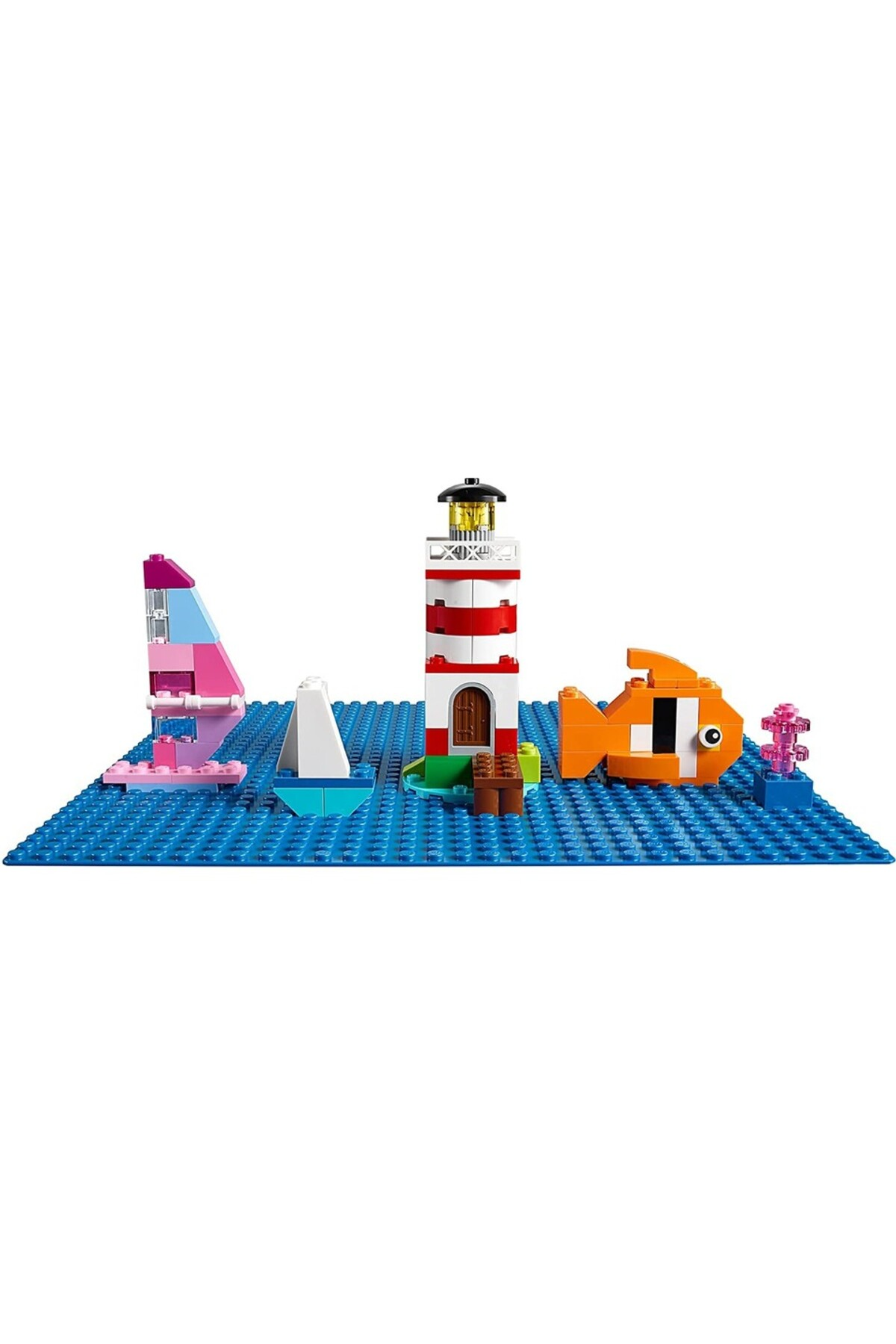 Mavi zemin üzerinde deniz feneri, tekne, yelkenli, balık ve mercan içeren Lego modeli.