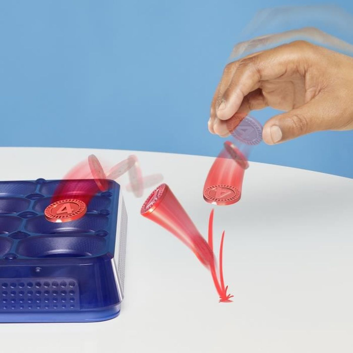 Hand wirft Spielstein in rotes Rohr, das auf blauem Kasten liegt.