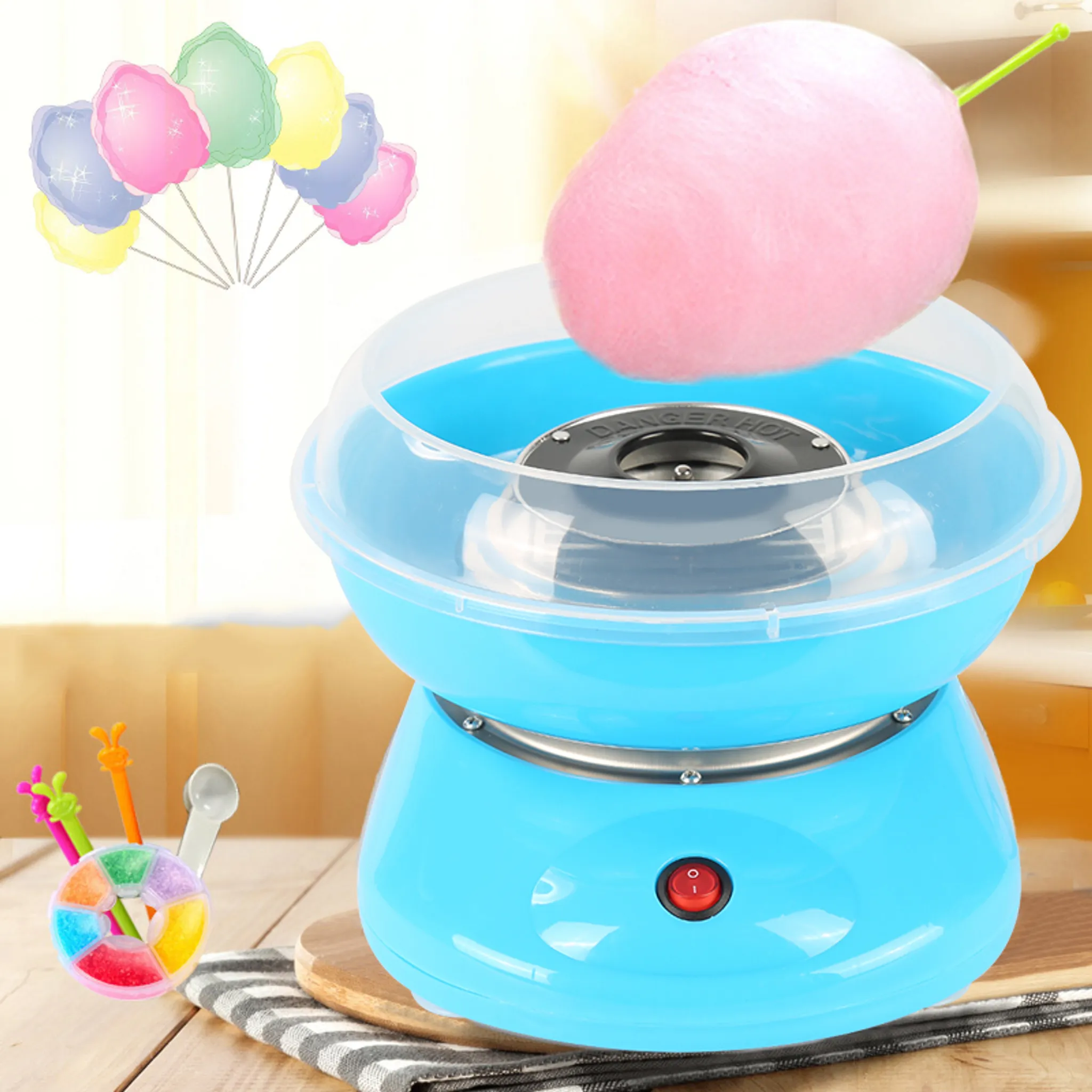Ein blauer Zuckerwattemaschine mit rosa Zuckerwatte, bunte Zuckerwatte-Sticks.