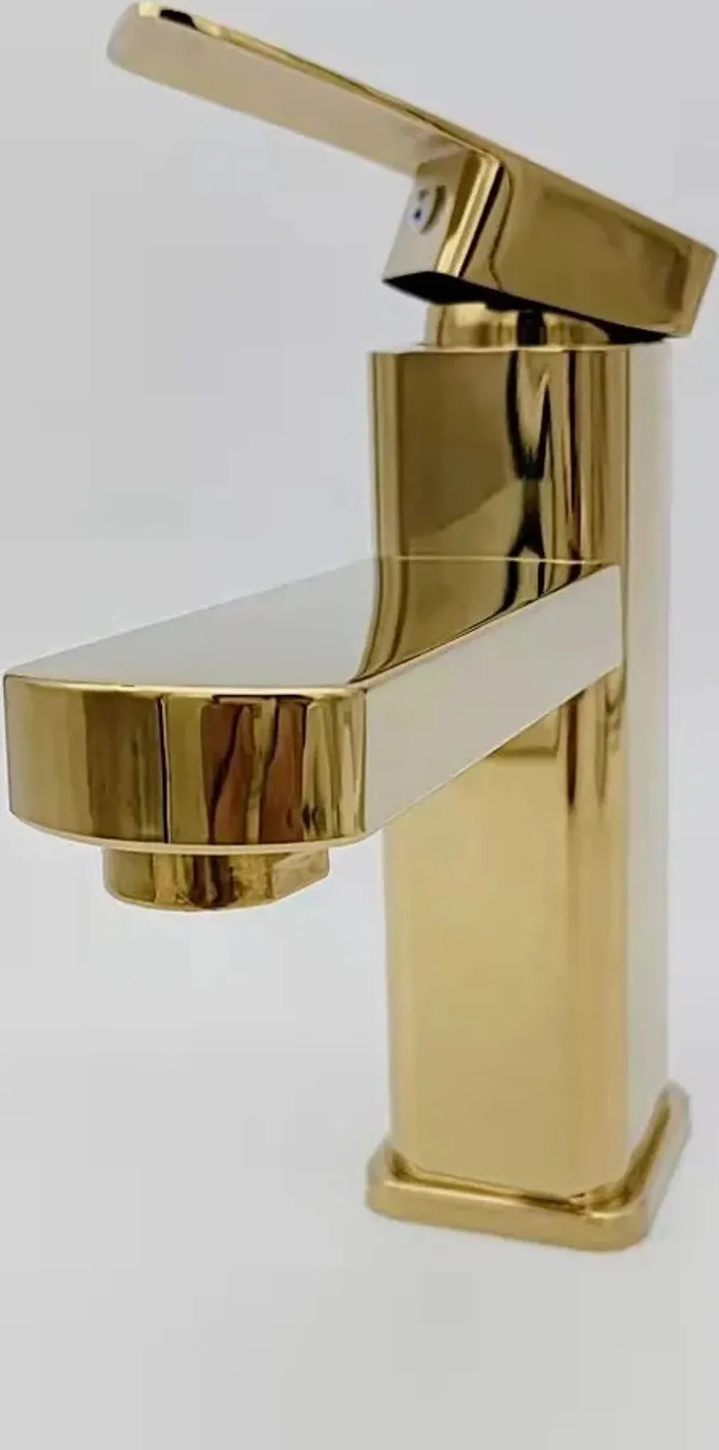Ein glänzender goldener Wasserhahn mit einer rechteckigen Basis und einem flachen Auslauf.