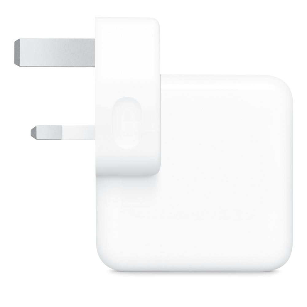 Un adaptateur secteur blanc avec trois broches argentées.