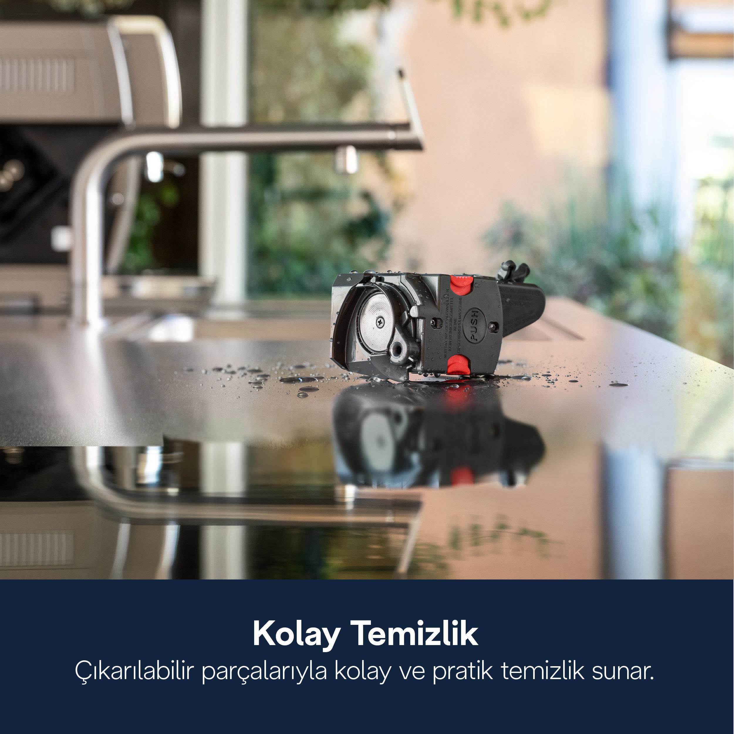 Kırmızı vurgulu siyah temizlik parçası metal yüzeyde duruyor.