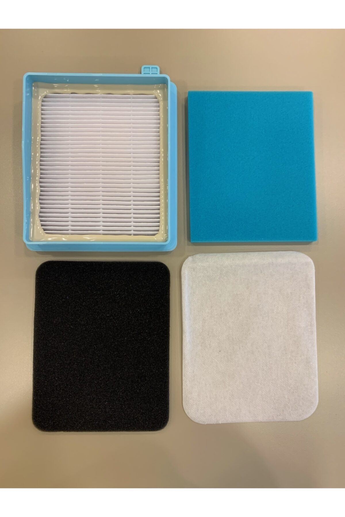 Dört filtre parçası: Mavi çerçeveli beyaz HEPA filtre, mavi sünger, siyah sünger, beyaz non-woven kumaş.
