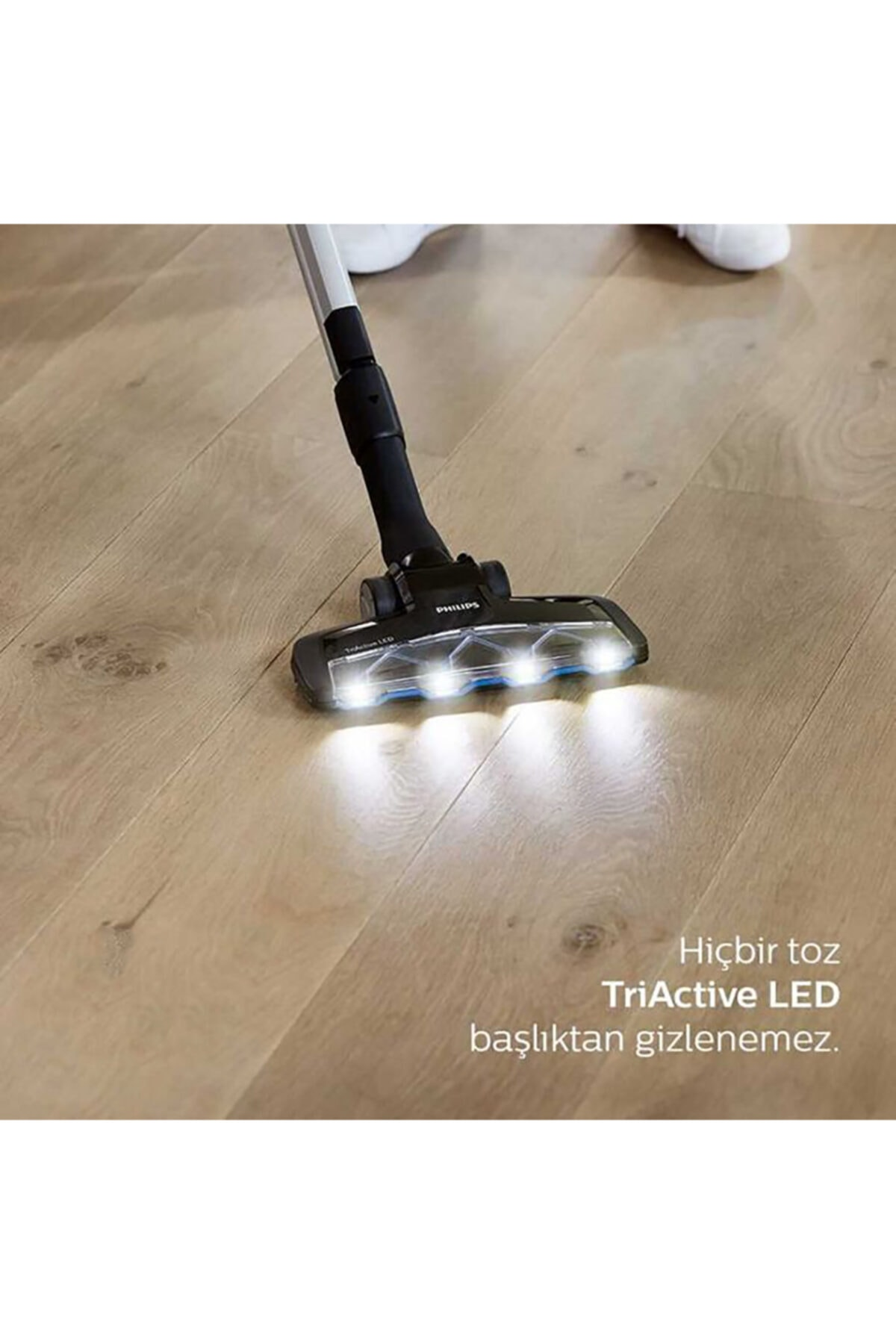 LED ışıklı elektrik süpürgesi başlığı ahşap zemini temizliyor.