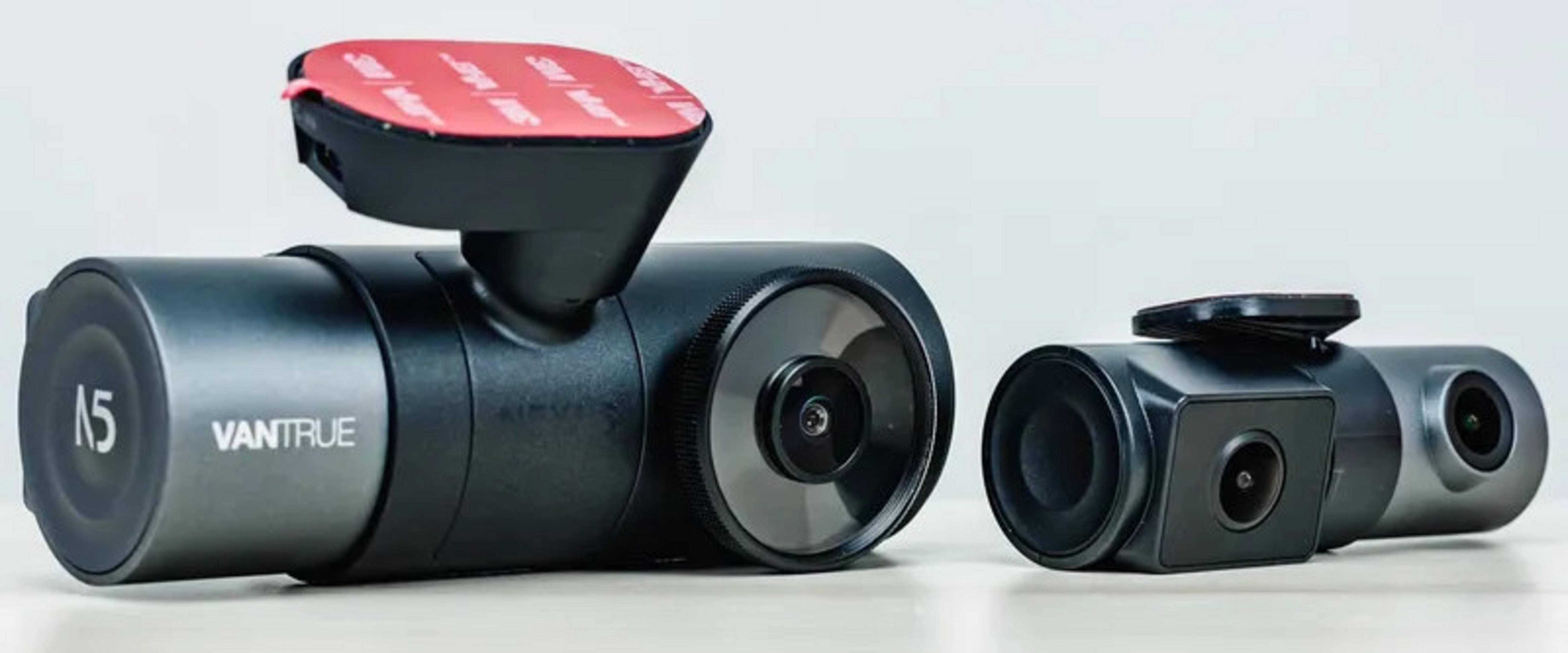 Dwa czarne wideorejestratory samochodowe na stole, jeden większy z czerwoną taśmą klejącą.