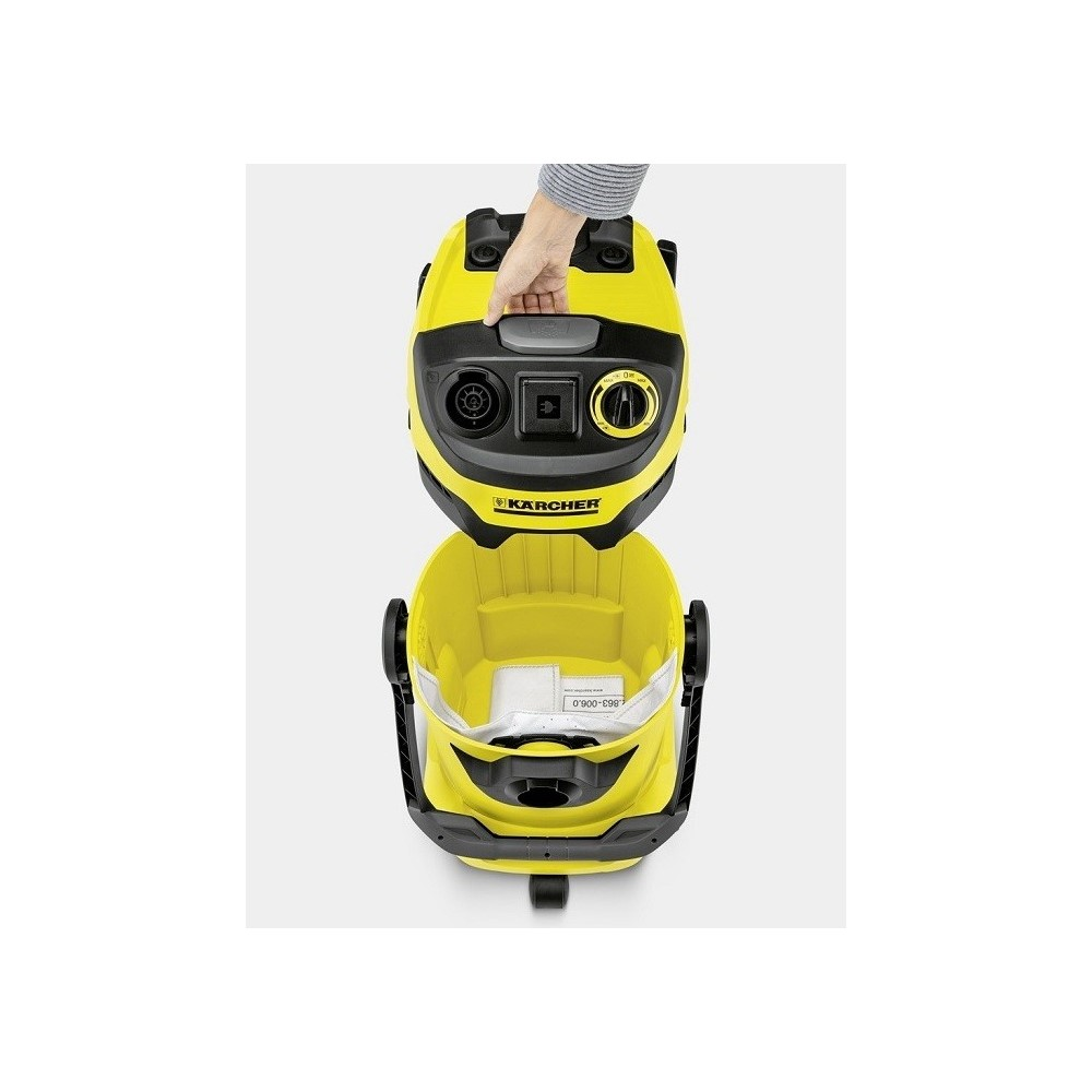 Sarı Karcher elektrikli süpürge, üst kısım çıkarılıyor. El tutamağı tutuyor.