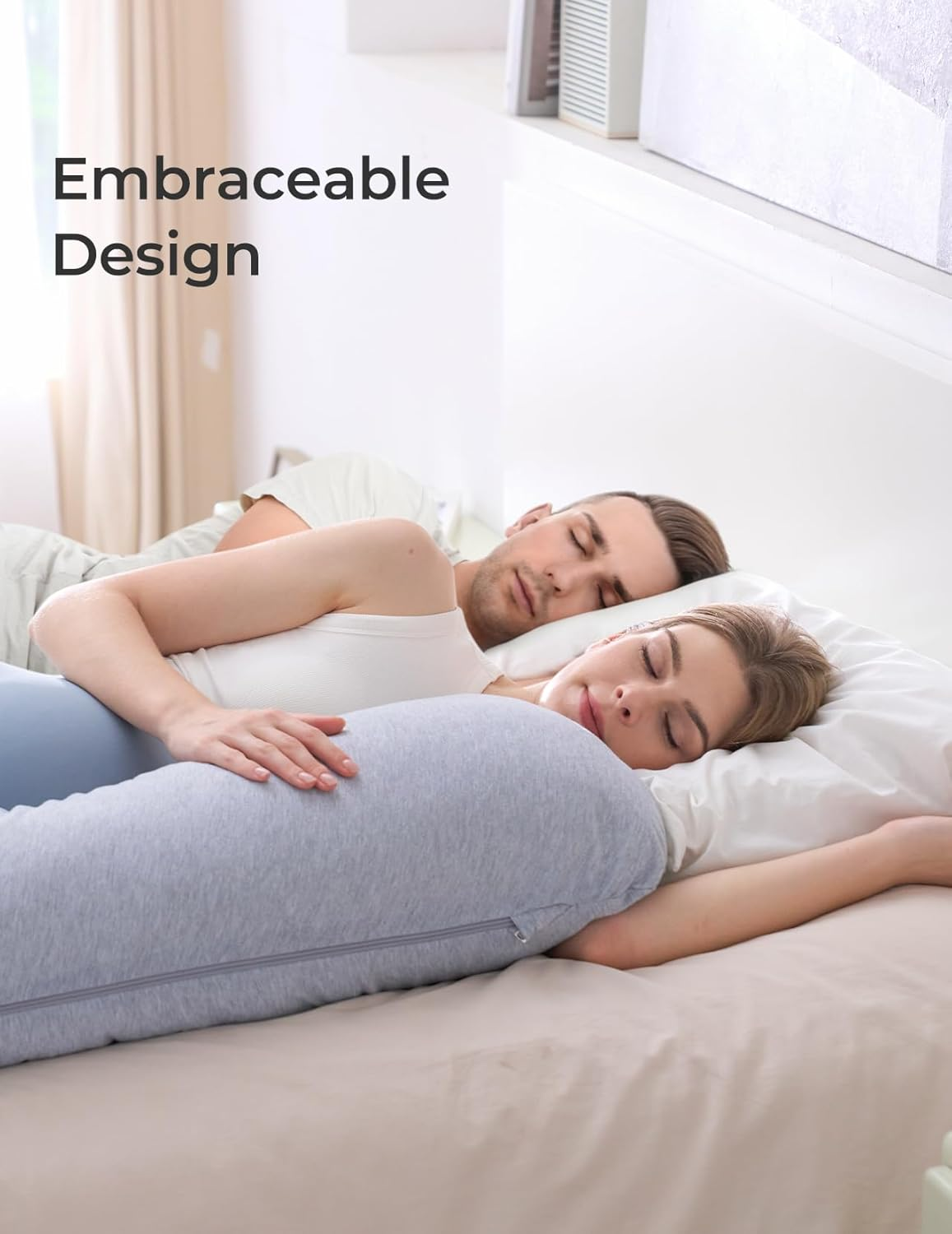 Un homme et une femme dorment blottis l'un contre l'autre, soutenus par un coussin gris.