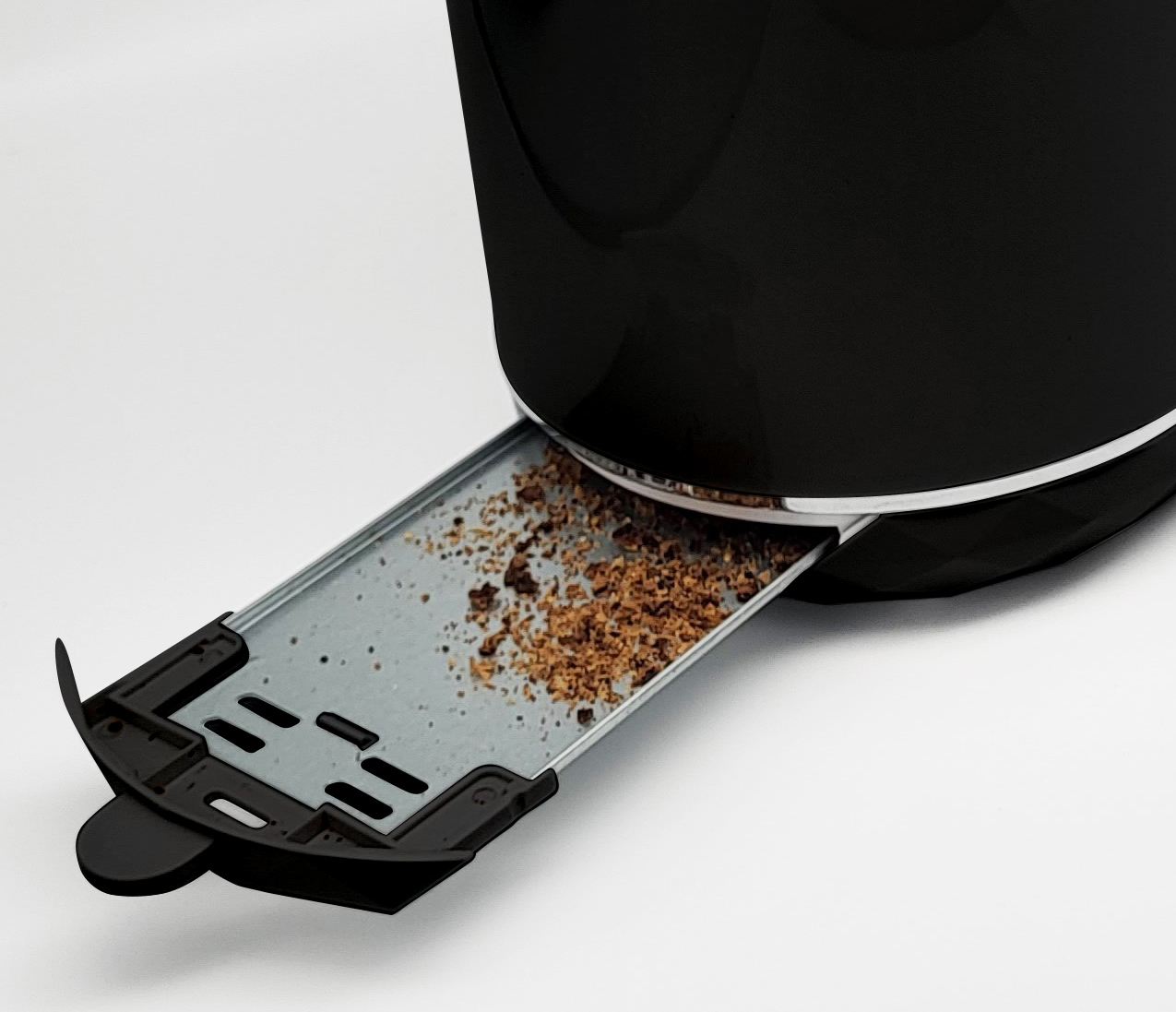 Ein schwarzer Toaster mit einem herausgezogenen Krümelfach voller Krümel.