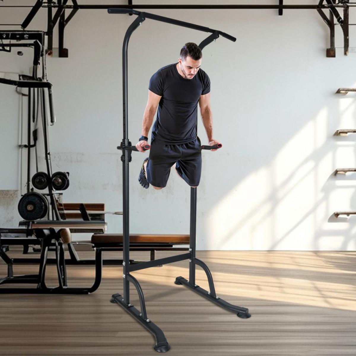 Mann macht Dips auf einem Klimmzugturm in einem Fitnessstudio mit Gewichten.