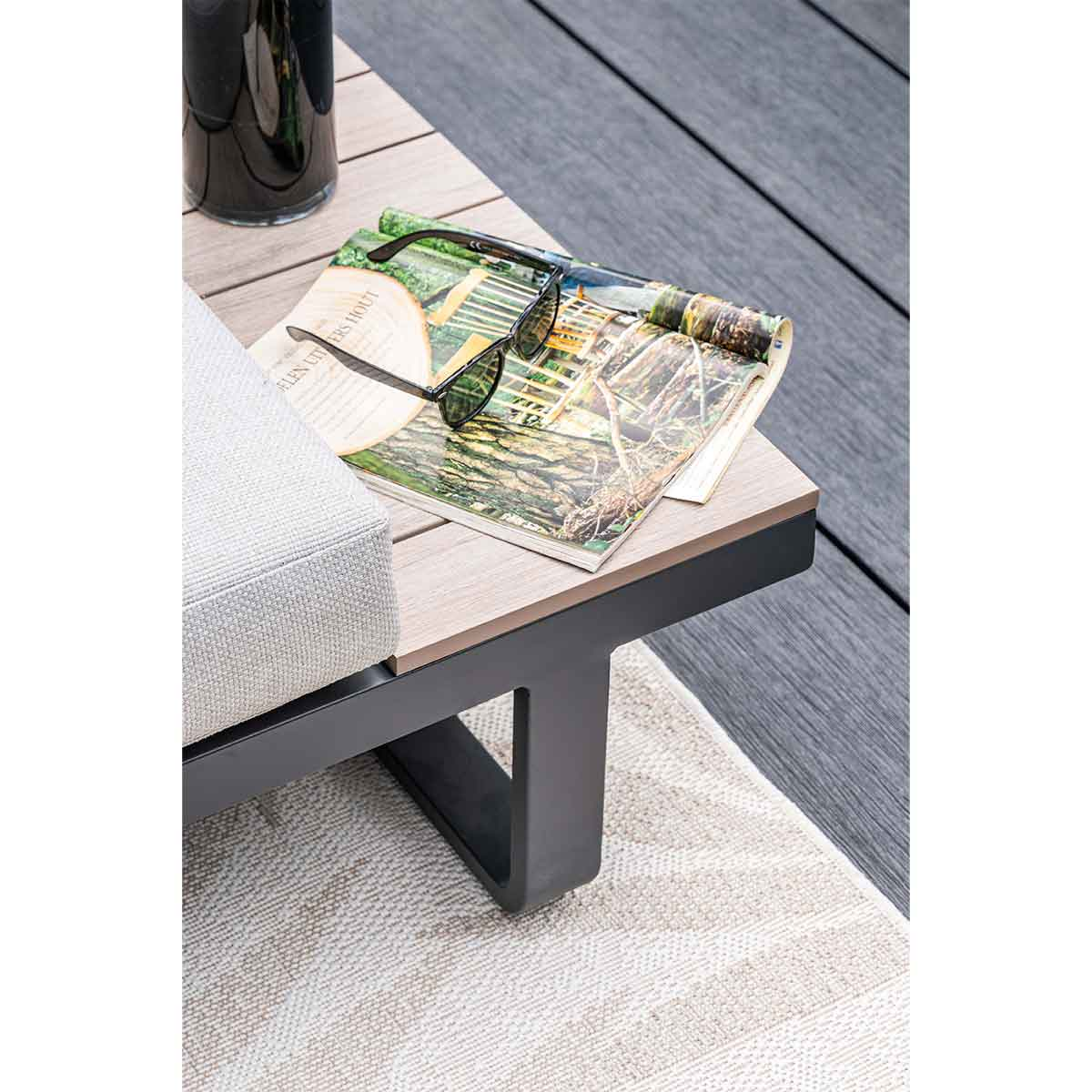 Lunettes de soleil sur un magazine posé sur une table en bois.