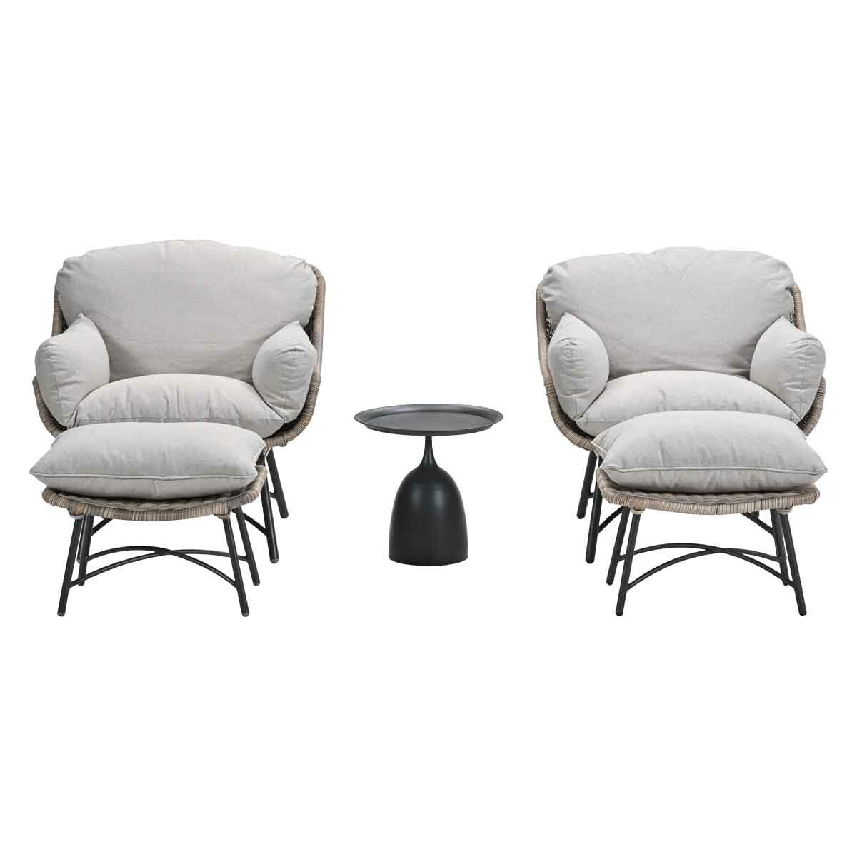 Two wicker chairs with ottomans and a small black side table.