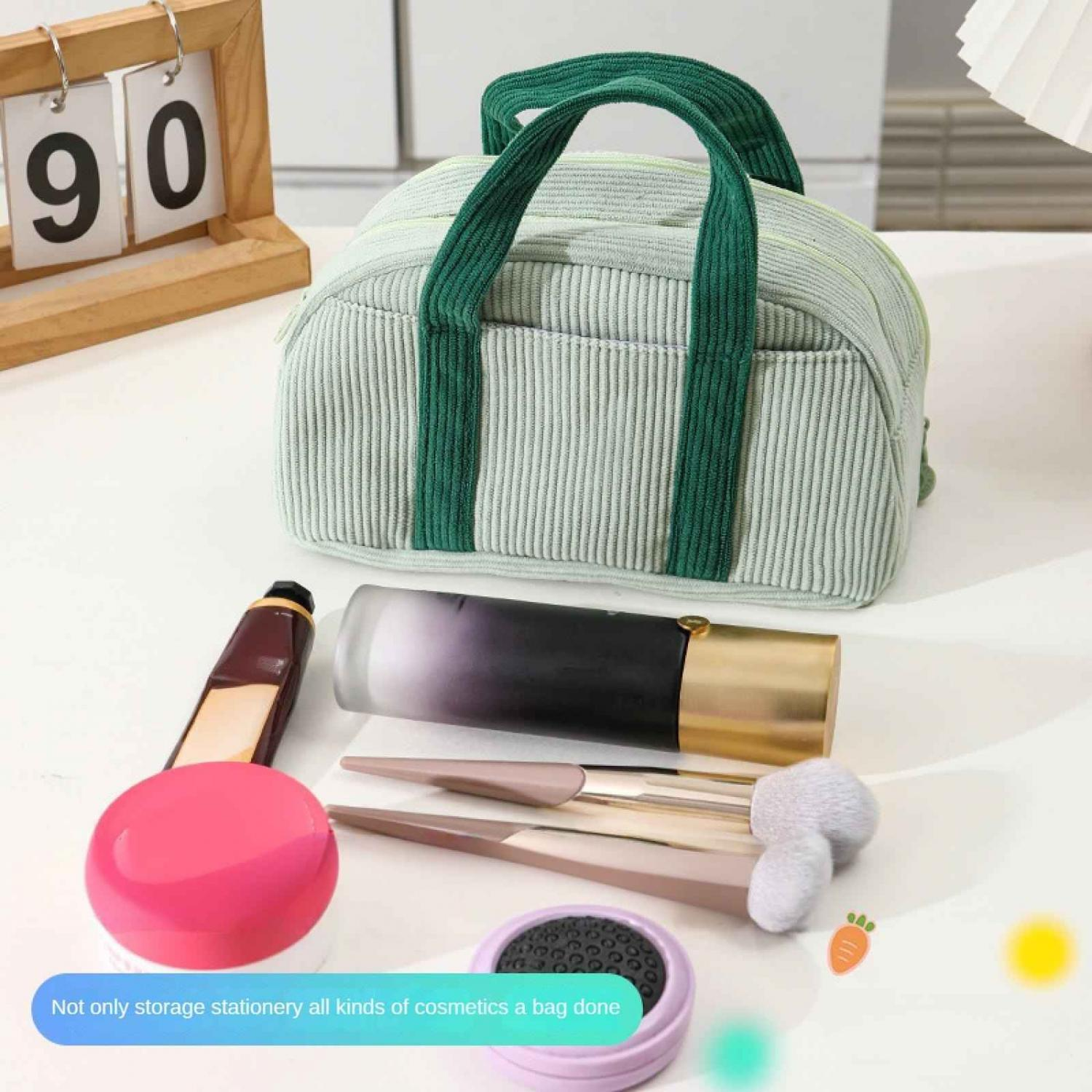 Ein hellgrüner Kosmetikkoffer mit grünen Griffen liegt neben Make-up-Artikeln.