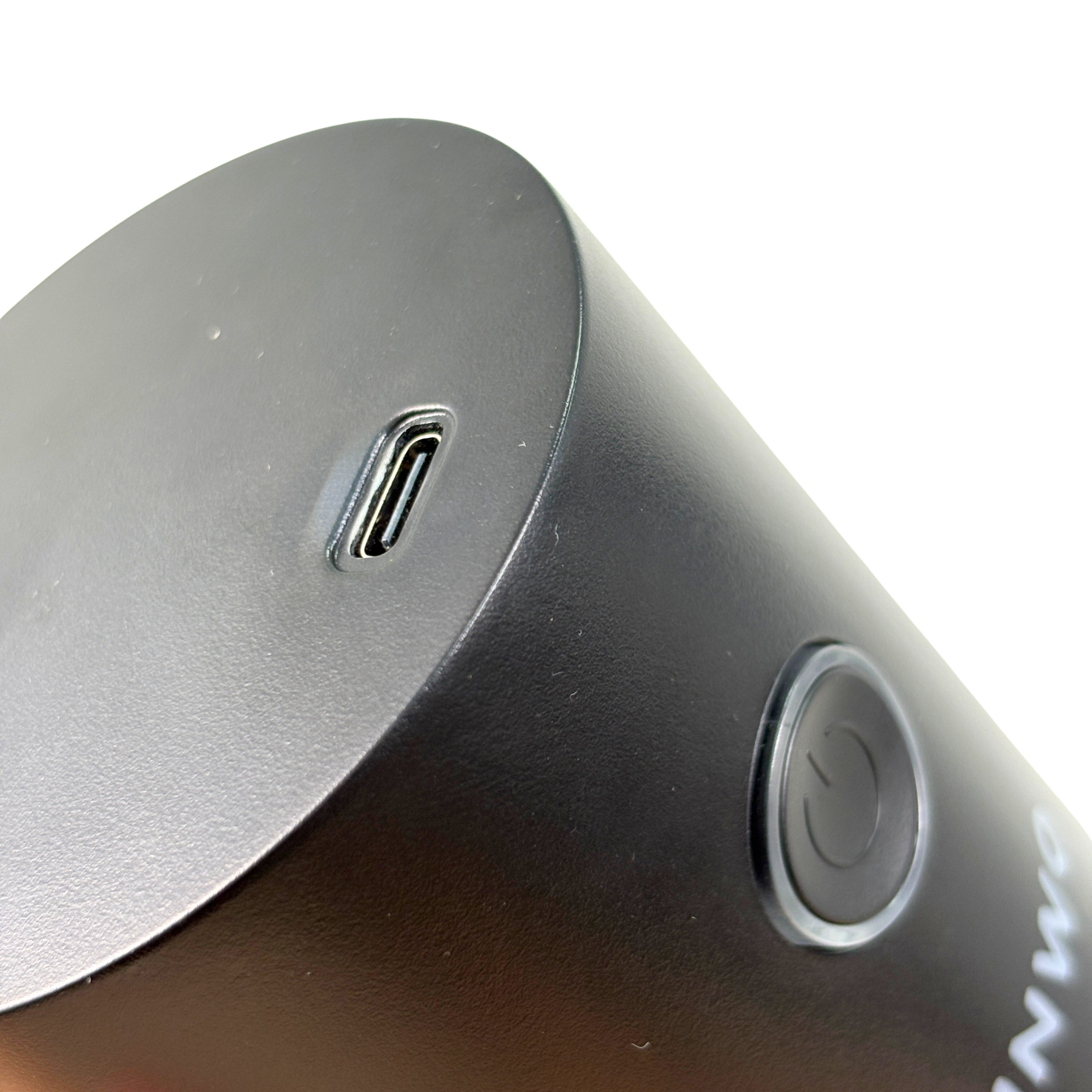 Primer plano de un dispositivo negro que muestra un puerto USB-C y un botón de encendido.