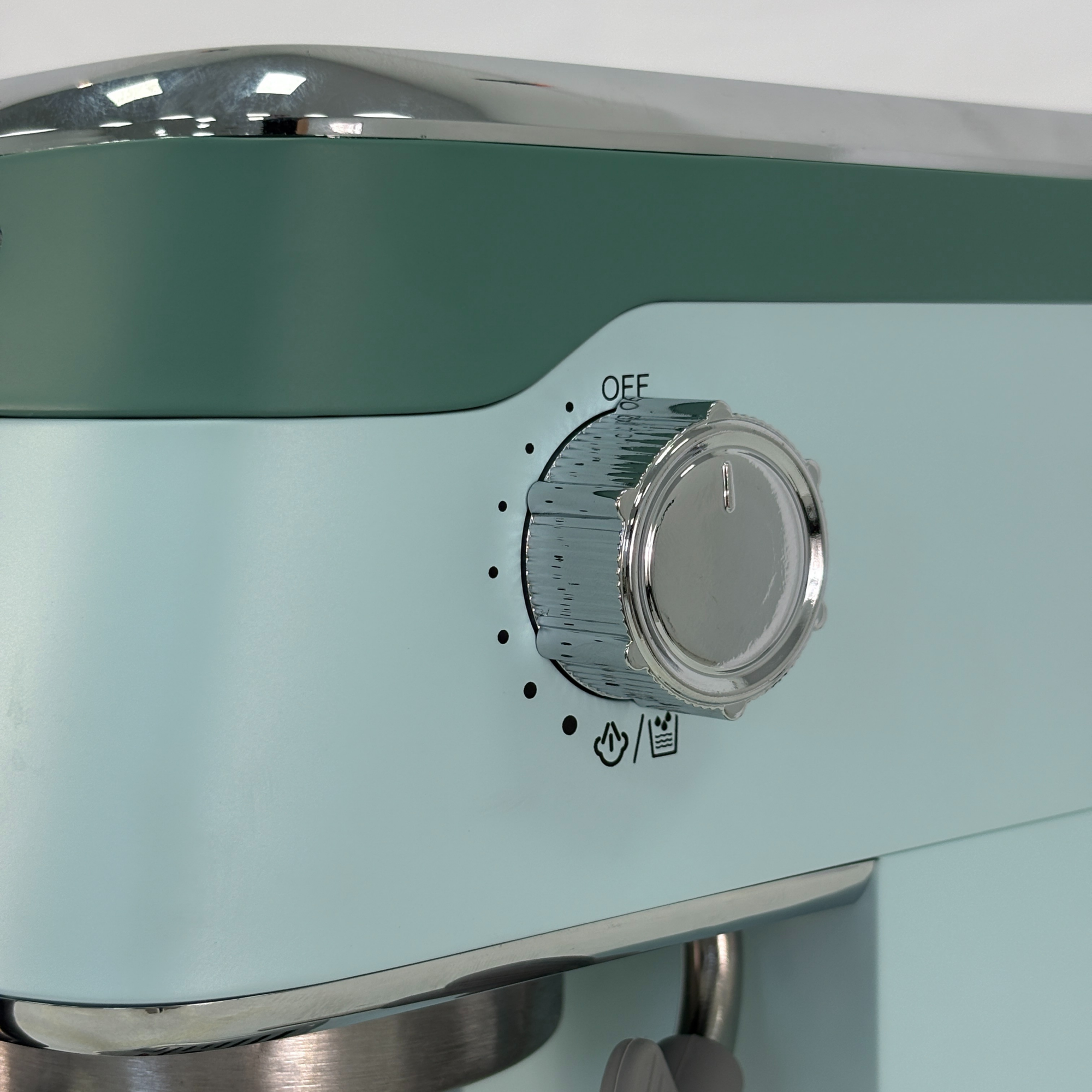 Un electrodoméstico azul claro con dial cromado e iconos de calor/agua.