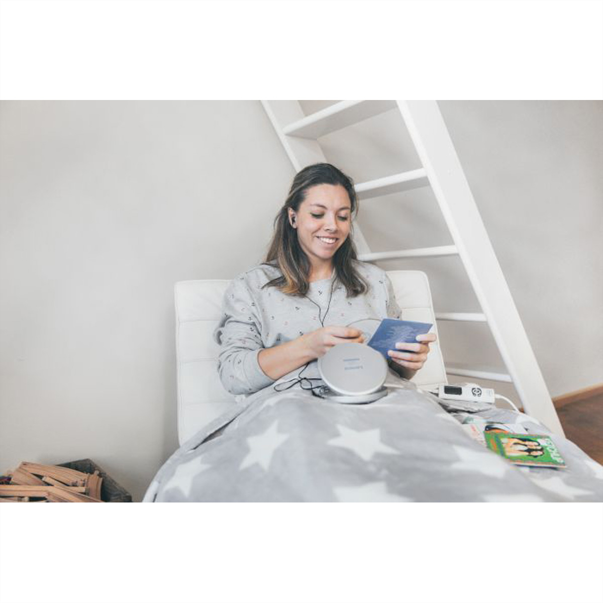 Kobieta siedzi, słuchając muzyki z odtwarzacza CD.