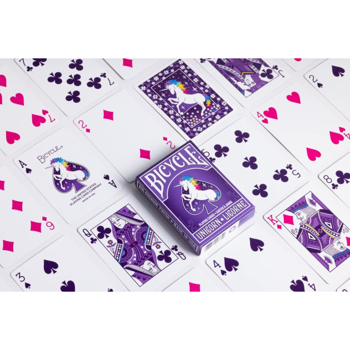 Lila Spielkarten mit Einhorn-Motiv, eine Schachtel und einzelne Karten.