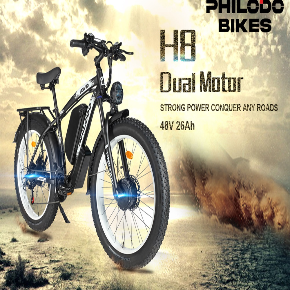 Schwarzes E-Bike mit fetten Reifen und Gepäckträger vor einer staubigen Landschaft.