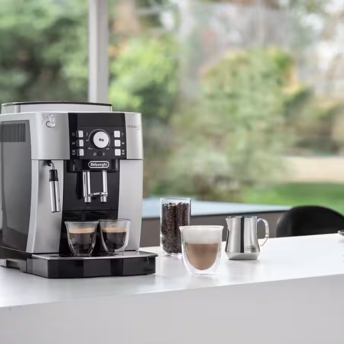 Srebrno-czarna maszyna do kawy z dwoma filiżankami espresso.