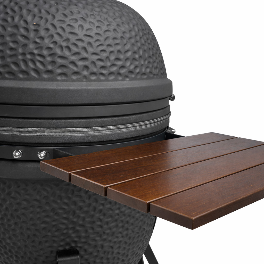 A black ceramic grill with a brown wooden side table and a textured lid.