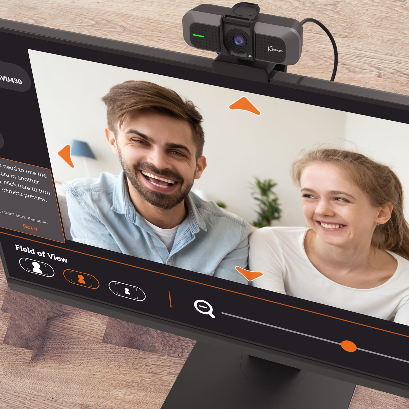 Ein Paar lachend vor einem Monitor, eine Webcam sitzt oben.