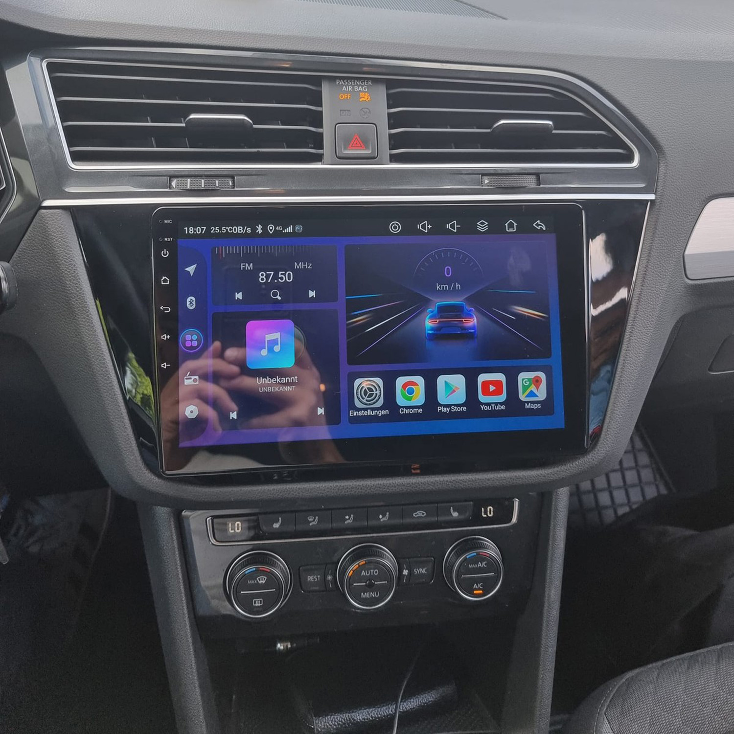 Cruscotto dell'auto con sistema di infotainment touchscreen che mostra radio, navigazione e app. Orologio 18:07.