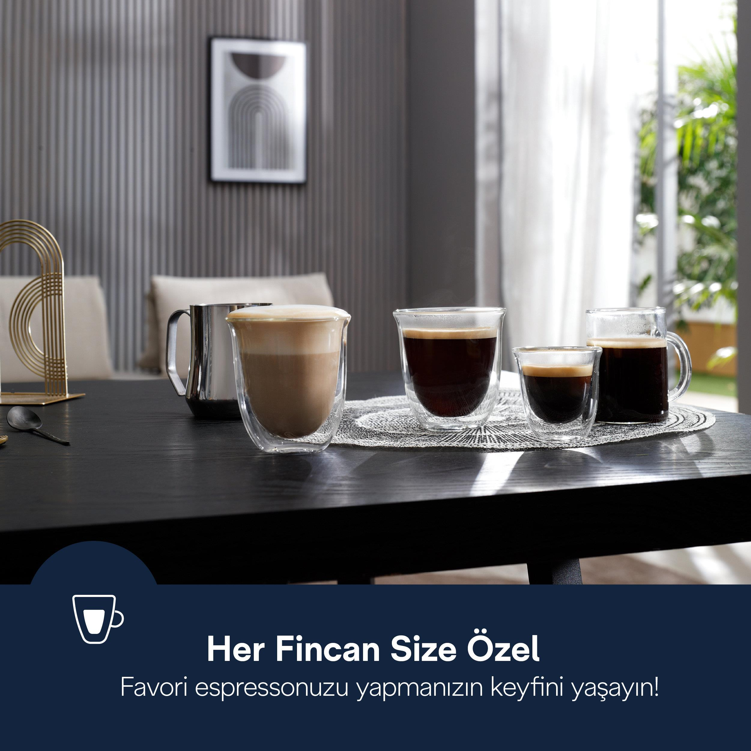 Cztery szklanki do kawy na drewnianym stole, z kącikiem wypoczynkowym przy oknie w tle.