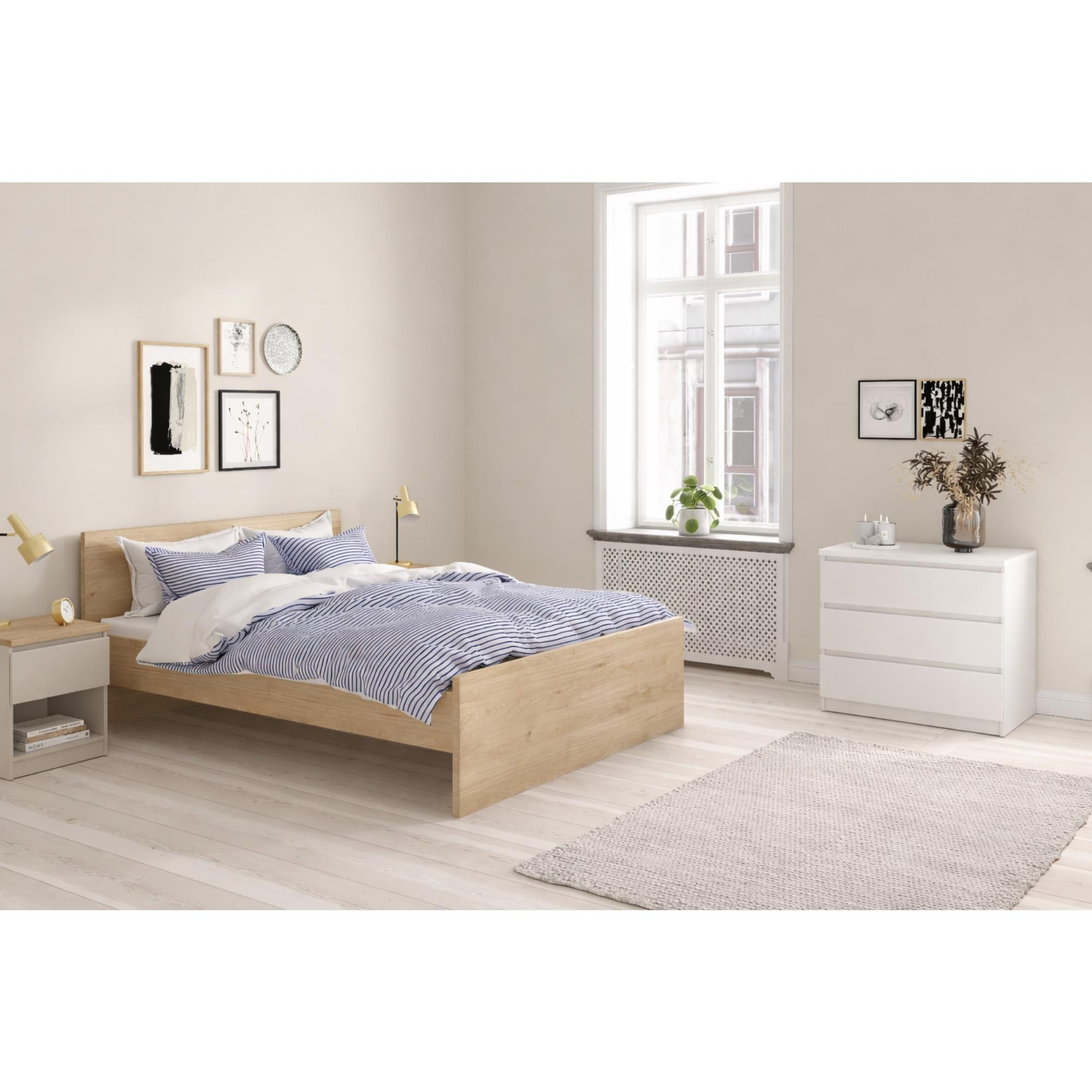 Cama de madera con ropa de cama a rayas azules, mesita de noche, cómoda y ventana.