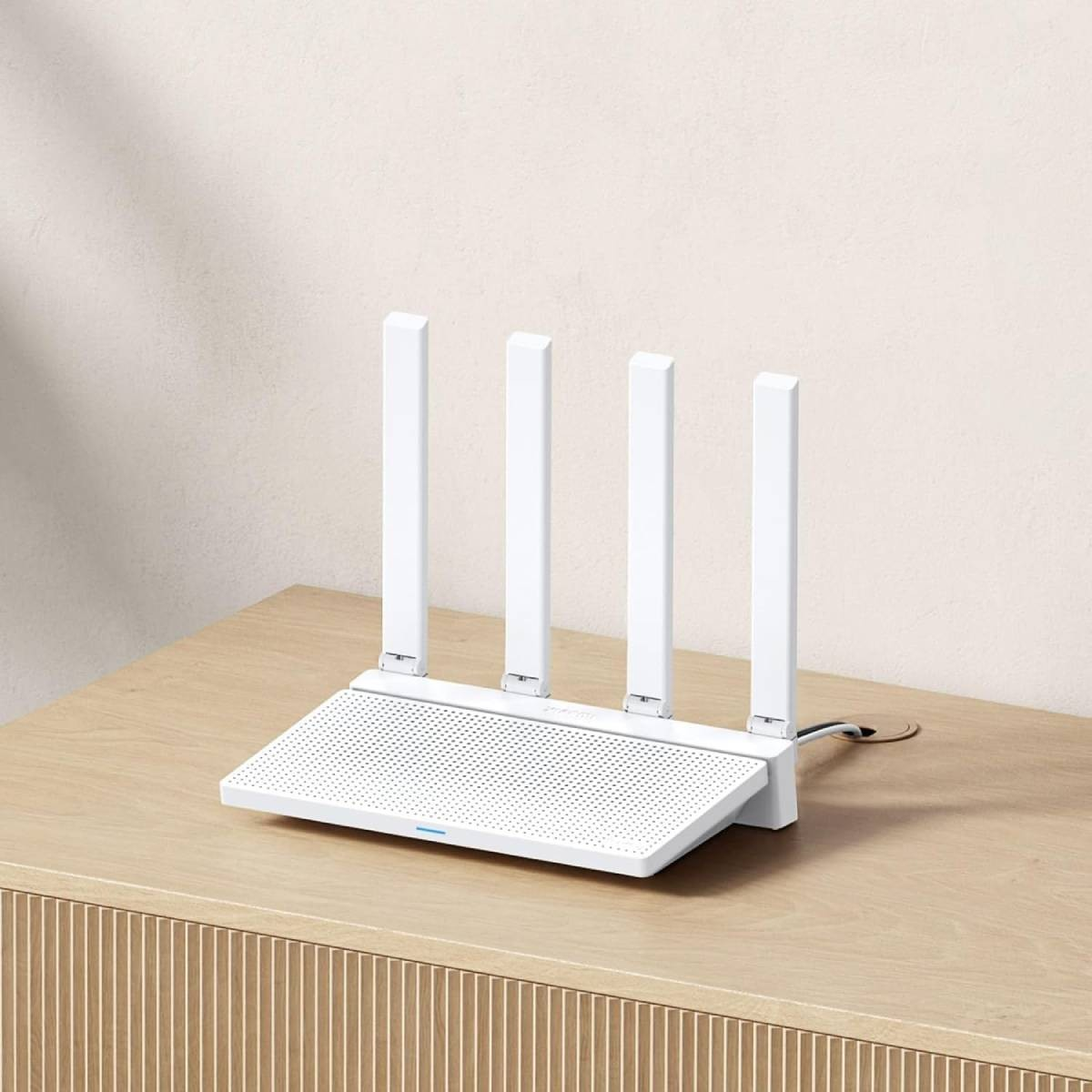 Un router Wi-Fi bianco con quattro antenne è su un tavolo di legno.