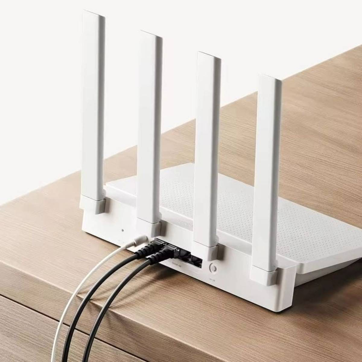 Un router WiFi bianco con quattro antenne e cavi collegati.