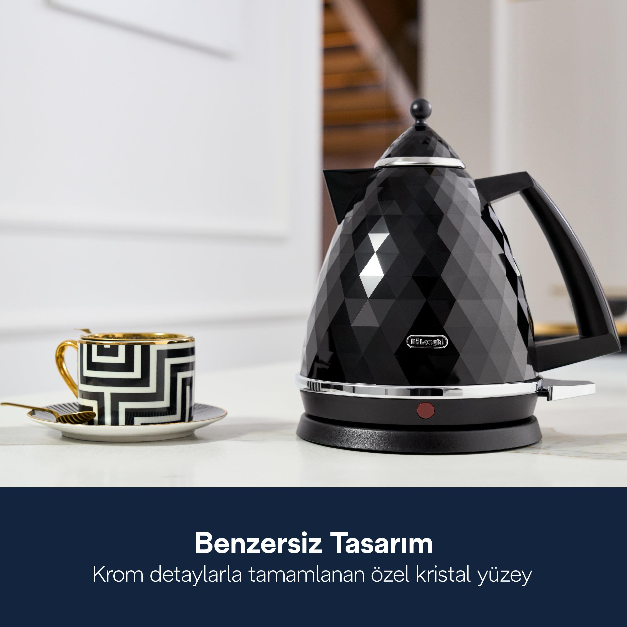 Czajnik w czarne wzory diamentowe obok złotego kubka z geometrycznym wzorem.